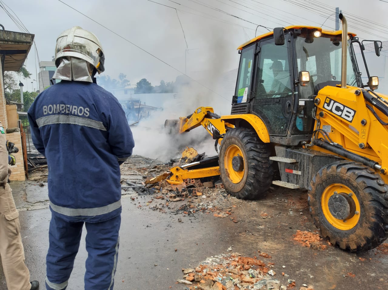 Bombeiros precisaram usar a retroescavadeira. (Foto: Mauricio Freire, da RIC TV | RECORD TV)