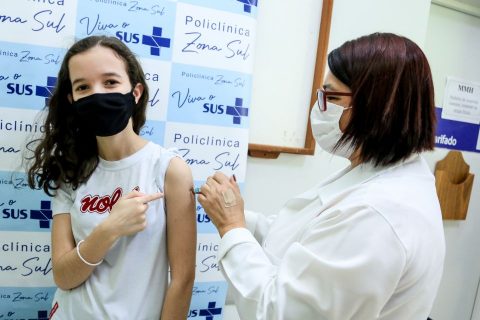  Adolescente sendo vacinada contra o Covid-19 