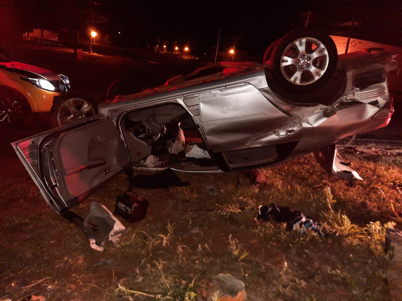  Carro Corolla prata para com as rodas para cima após capotamento 