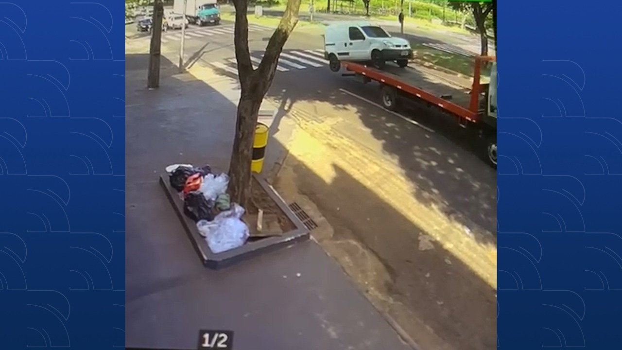  Imagem de câmera de segurança mostrando carro prestes a cair de um caminhão guincho em plena avenida 