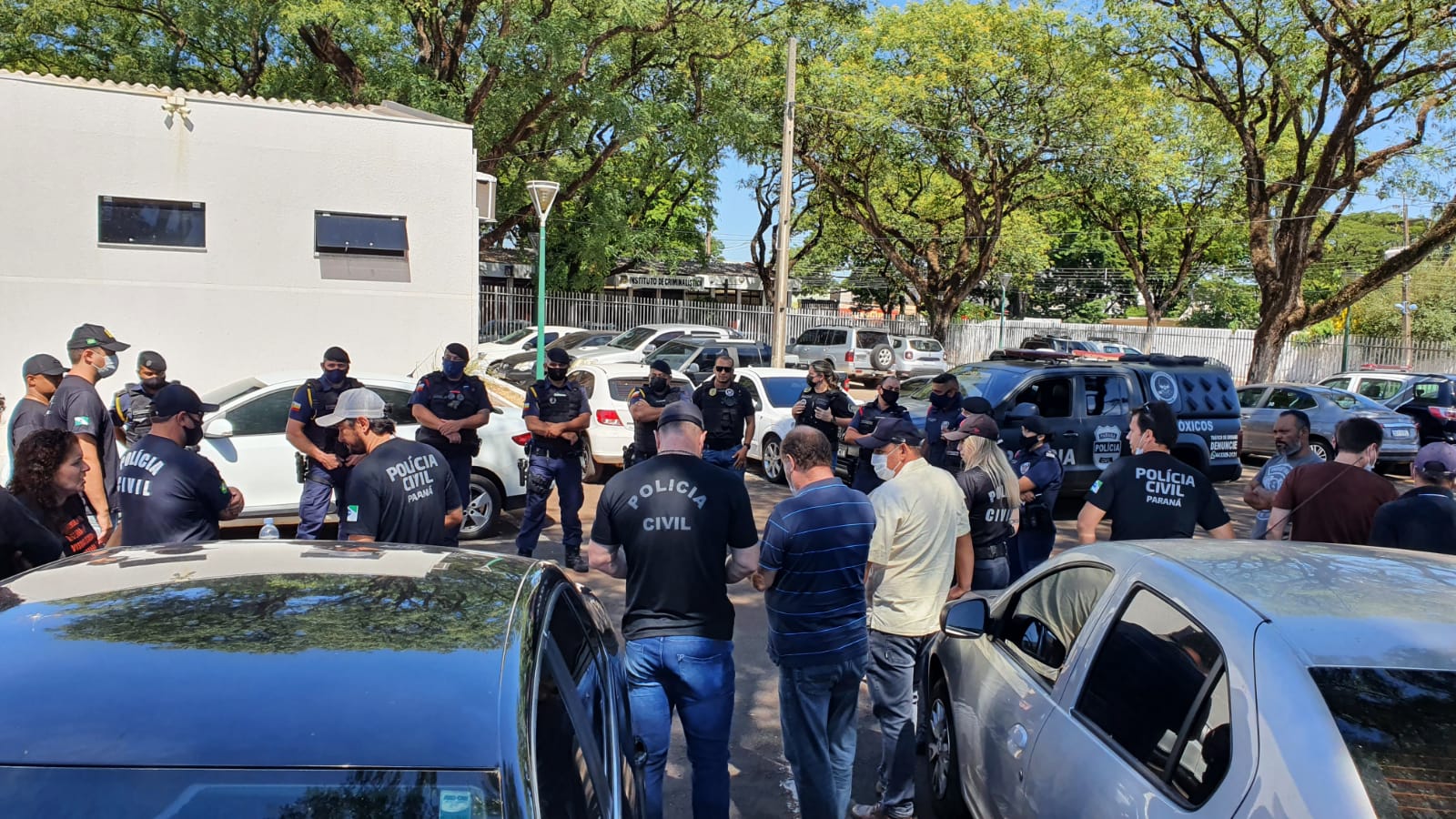  Policiais e guardas reunidos em círculo, em frente à delegacia de Maringá, em preparação para a operação 