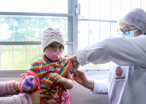  Profissional da saúde aplica vacina em criança 