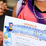 Criança segura certificado de 'superproteção' enquanto toma vacina