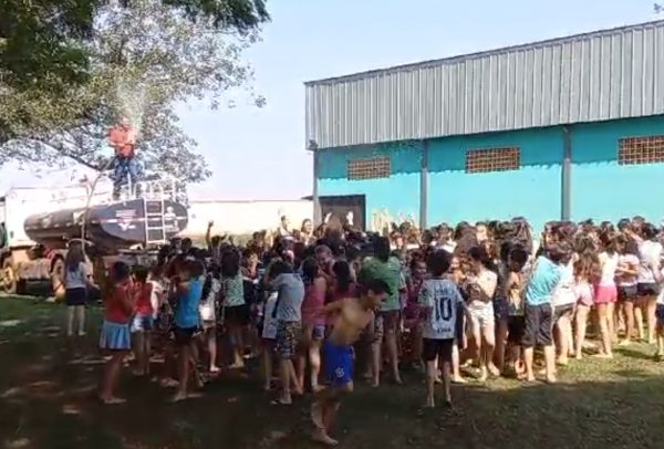 crianças tomando banho de mangueira