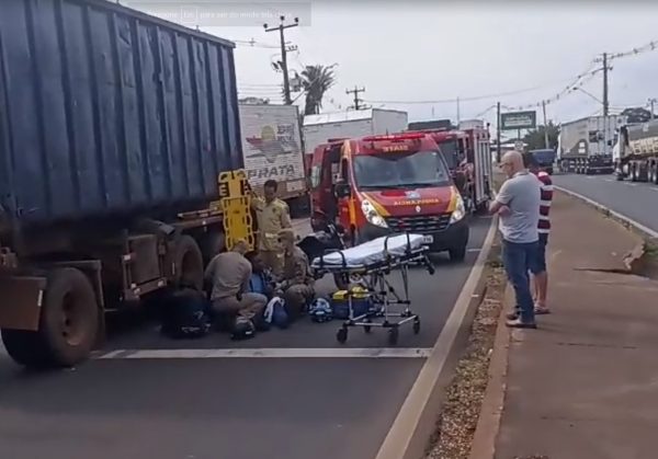 motociclista para embaixo roda caminhão