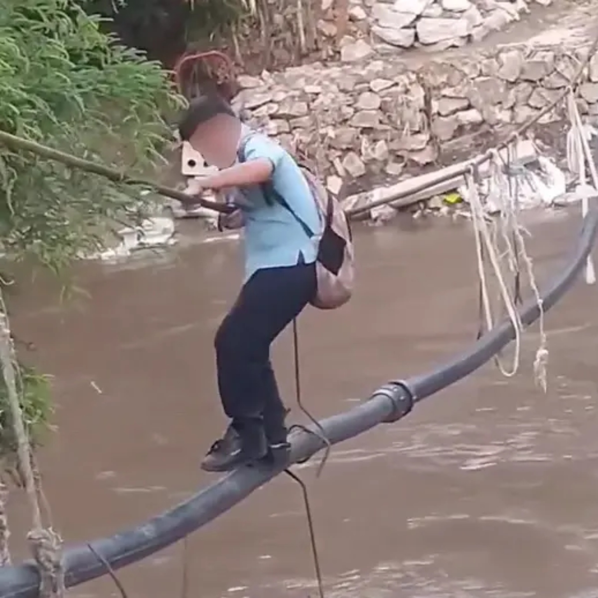  Crianças atravessam rio em cano para chegarem na escola 