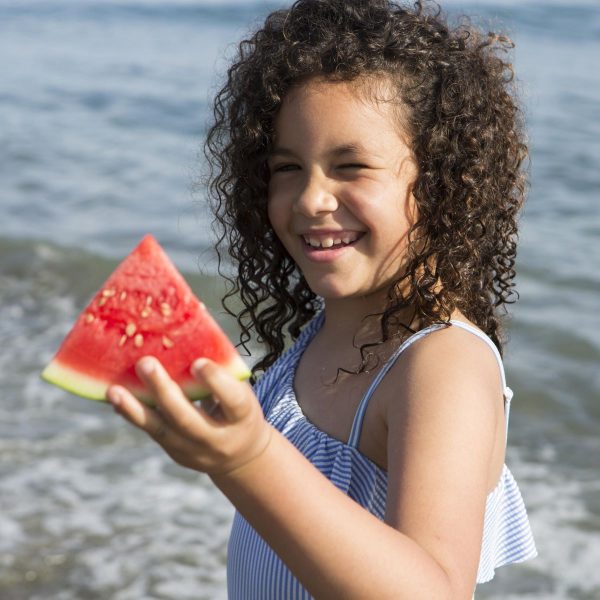 criança fruta praia