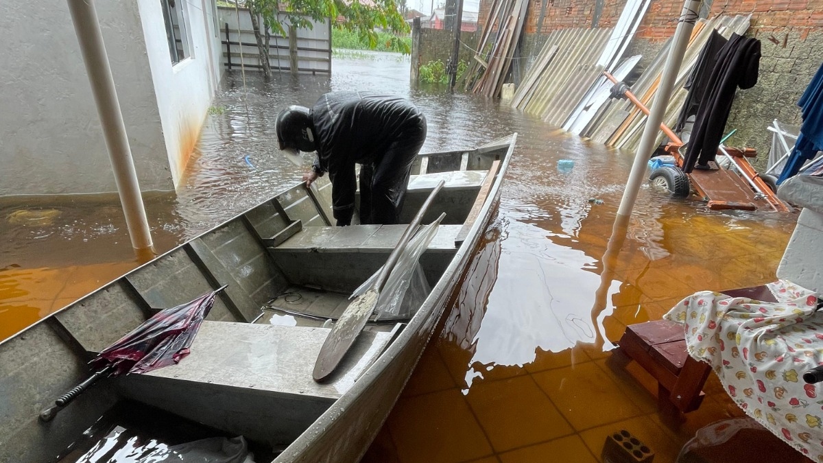  casas alagadas e bombeiros com barco retirando famílias 