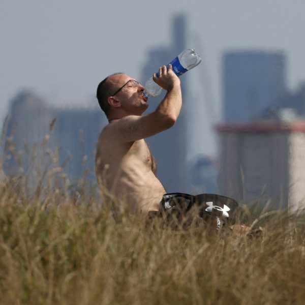 Pessoa tomando água em dia muito quente em 2023