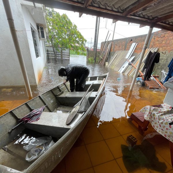Barco resgata moradores em alagamento, em Guaratuba