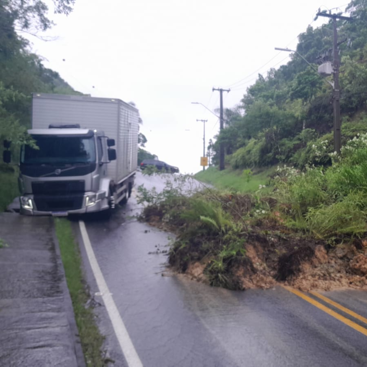  desmoronamento em avenida com caminhão ao lado, ilustrando uma matéria sobre o bloqueio do acesso ao ferry boat de guaratuba 