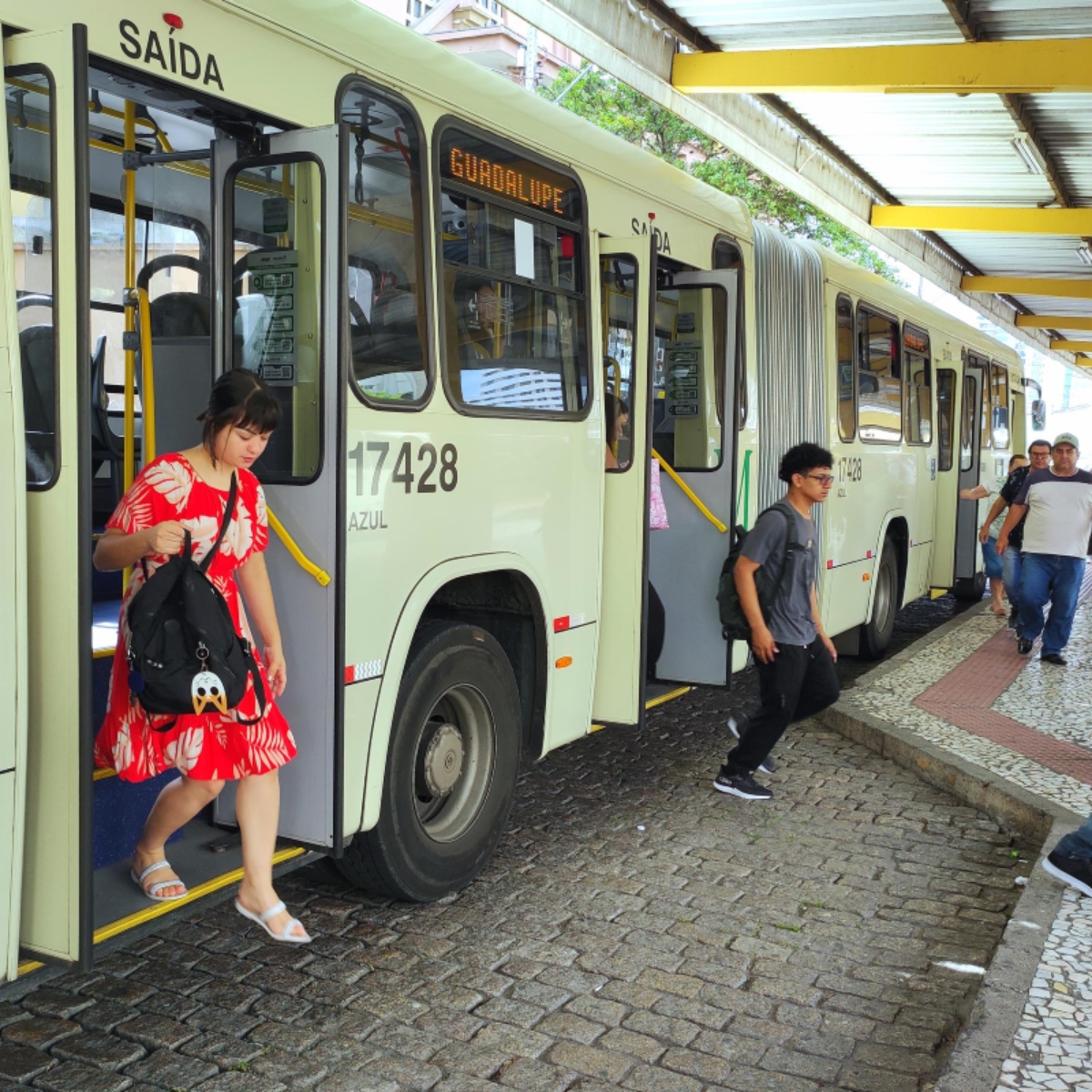  pessoas descendo de ônibus da amep na região metropolitana 