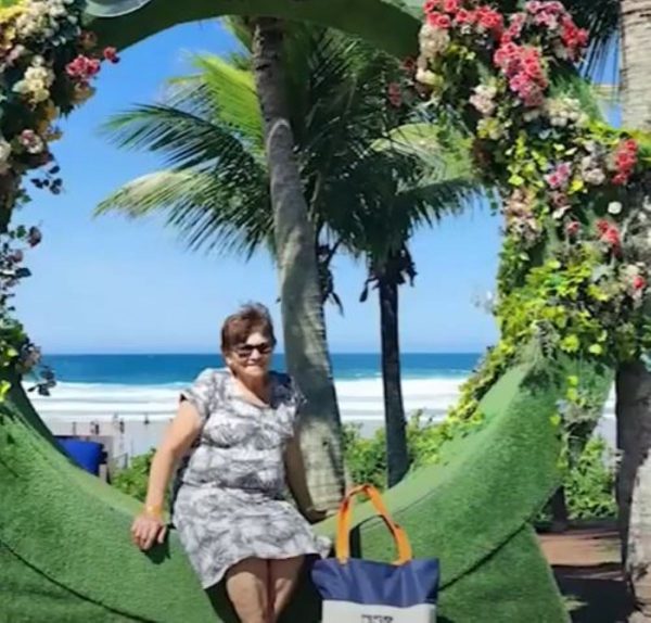 idosa fazendo pose em portal de praia