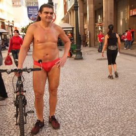 Ele é conhecido por andar de bicicleta apenas de sunga e óleo pelo corpo pelas ruas da capital