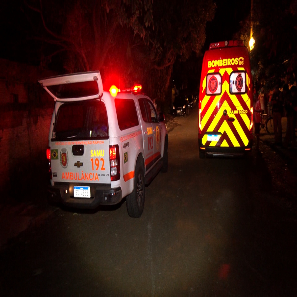 Viatura do SAMU e ambulância do Corpo de Bombeiros em frente à casa da vítima.