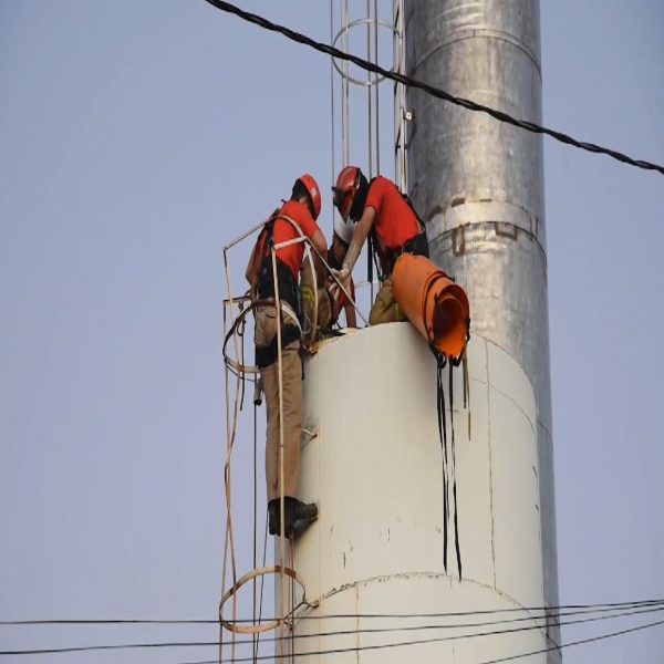 Imagem mostra equipe do Corpo de Bombeiros tentando retirar o corpo da vítima de dentro da caixa d'água.