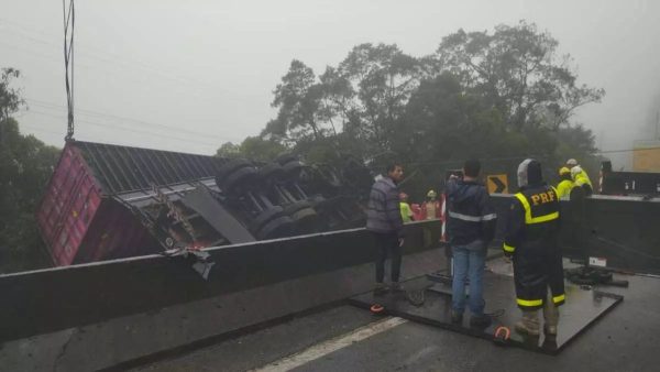 Veículo branco no fundo de um vale, com um pequeno riacho à frente