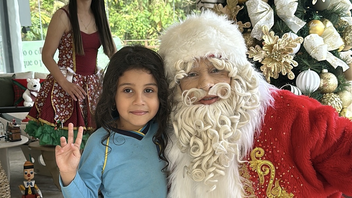 Papai Noel e menina abraçados